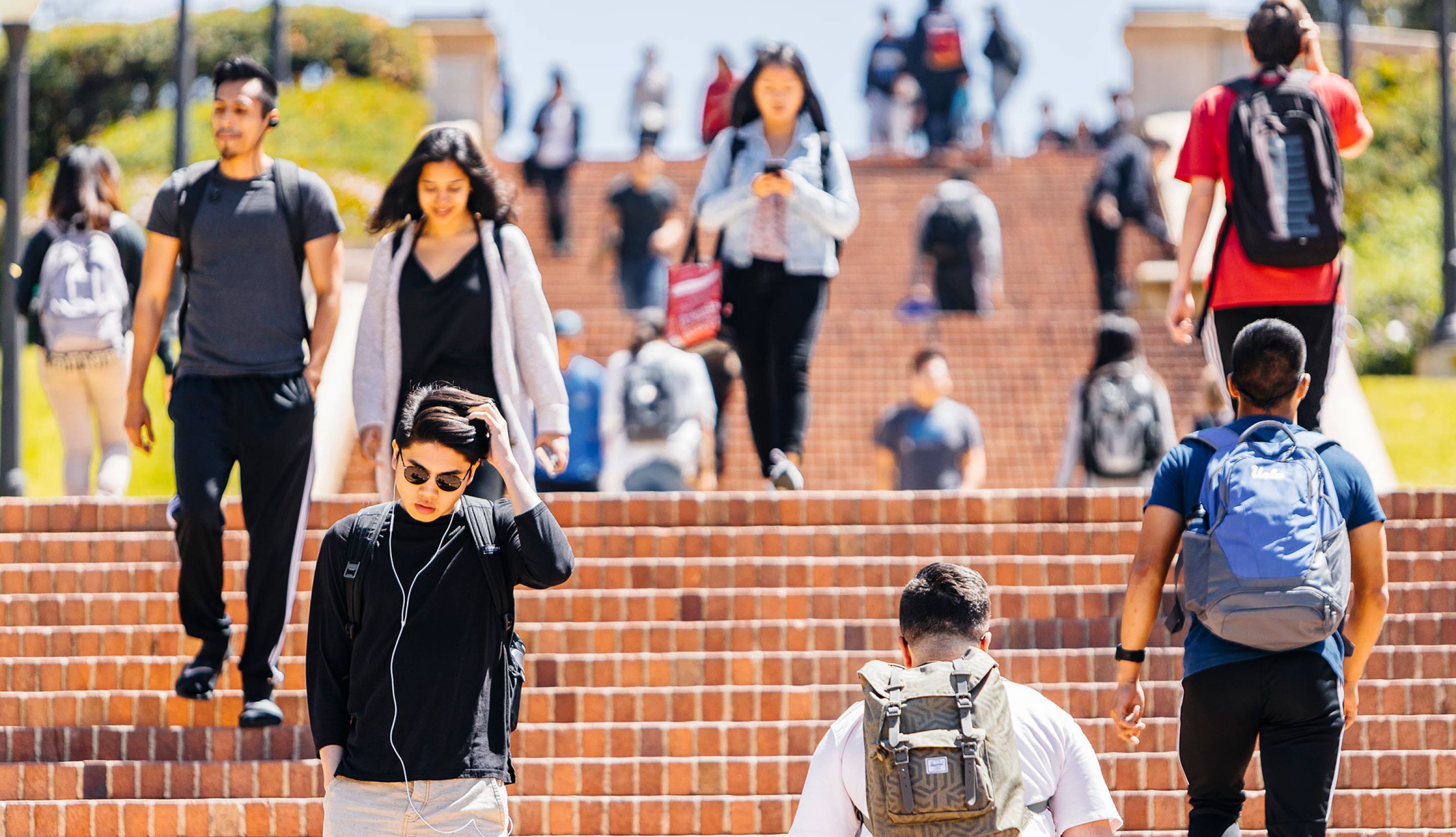 Students walking up and down brick stairs on campus